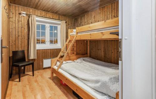 a bedroom with a bunk bed with a chair and a window at Awesome Home In Svingvoll With Sauna in Svingvoll