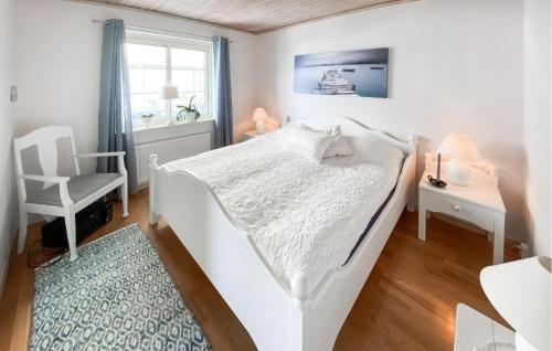 a bedroom with a white bed and a chair at Beautiful Home In Uddevalla With Wifi in Uddevalla