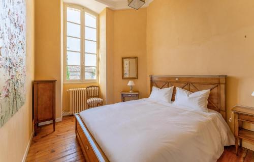 a bedroom with a white bed and a window at Le Clos Montaugé in Virsac