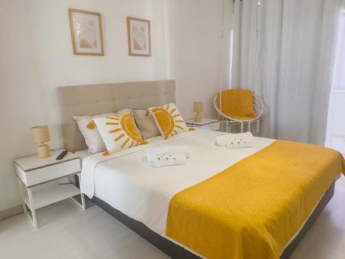 a bedroom with a large bed with a yellow blanket at Riamar House - Faro City Center in Faro