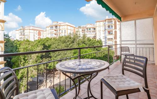 a balcony with a table and chairs and some buildings at Nice Apartment In Fuengirola With Wifi in Fuengirola