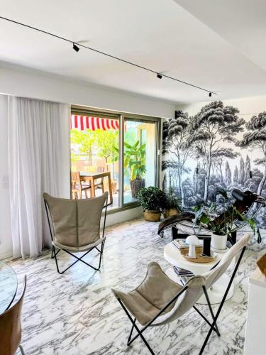 - un salon orné d'une fresque murale représentant des arbres dans l'établissement Splendide penthouse au coeur de Nice, à Nice