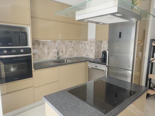 a kitchen with a stainless steel refrigerator and a sink at Riamar House - Faro City Center in Faro