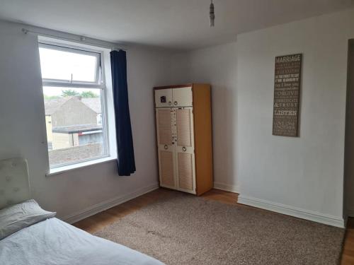 a bedroom with a refrigerator and a window at Lovely Home in Nelson in Nelson