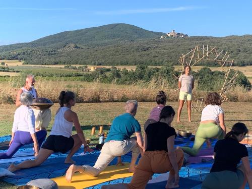 a group of people doing yoga on a blanket at Casale Artemisia Capalbio in Capalbio