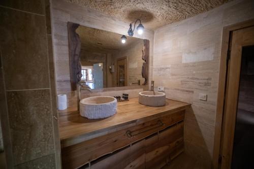 two sinks in a bathroom with a large mirror at Urgup Evi Cave Hotel in Ürgüp
