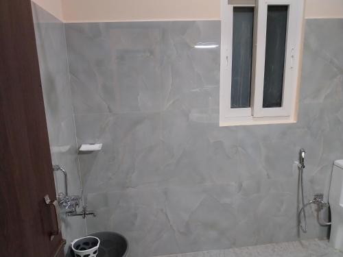 a bathroom with a sink and a toilet and a window at Bononi in Jorhāt