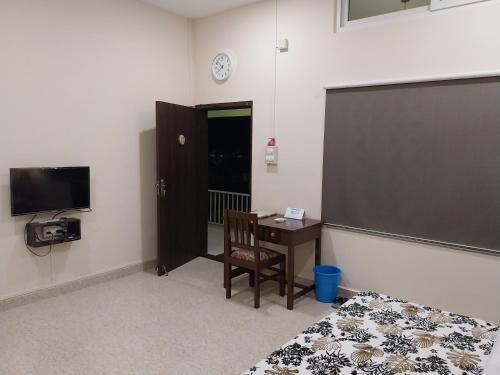 a room with a classroom with a desk and a chalkboard at Bononi in Jorhāt