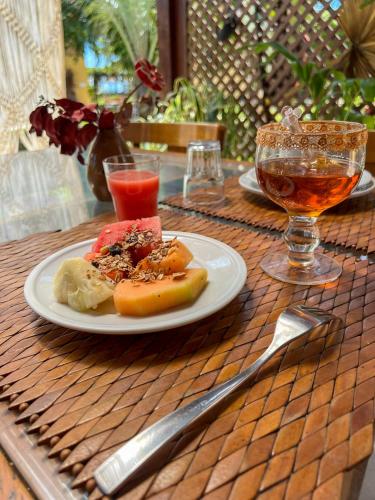 een bord eten op een tafel met een drankje bij Pousada do Paiva in Flecheiras