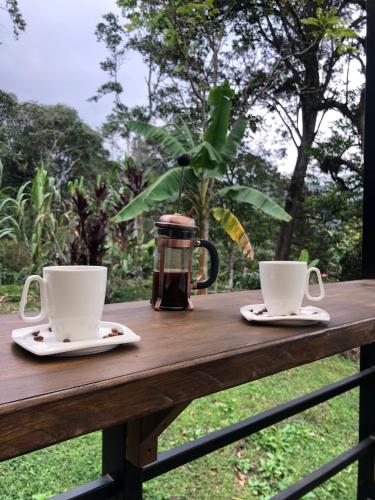 two coffee cups sitting on a wooden table at Cabaña tipo glamping en finca cafetera con zonas verdes, avistamiento de aves, paisaje cafetero in San Francisco