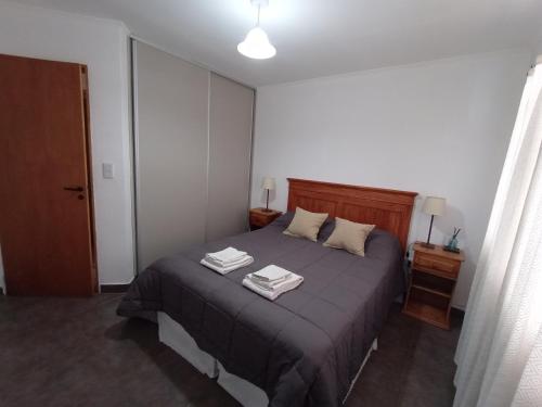 a bedroom with a bed with two towels on it at La Casita in Esquel