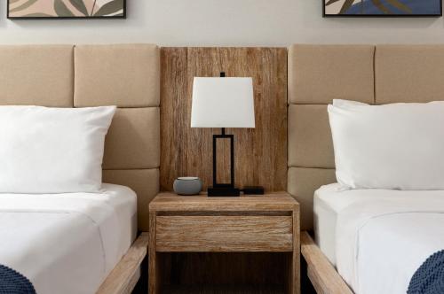 a bed room with two beds and a table with a lamp at The Wave at Marblehead in Marblehead