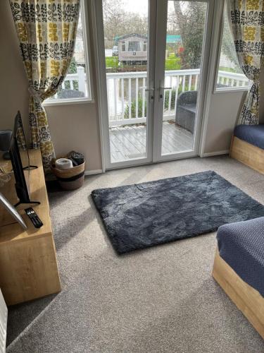 a living room with a rug in front of a door at On the Lake Weeley in Weeley