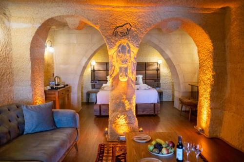 a living room with a couch and a room with a bed at Urgup Evi Cave Hotel in Ürgüp