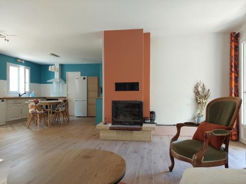 un salon avec cheminée et une cuisine dans l'établissement Sérénité, à Audrix