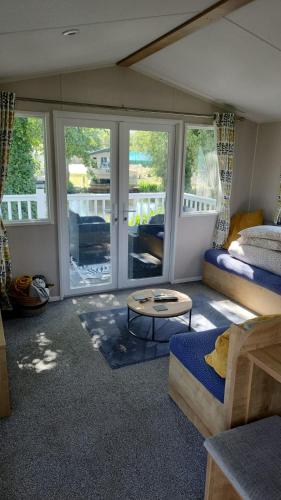 a living room with a bed and a table at On the Lake Weeley in Weeley