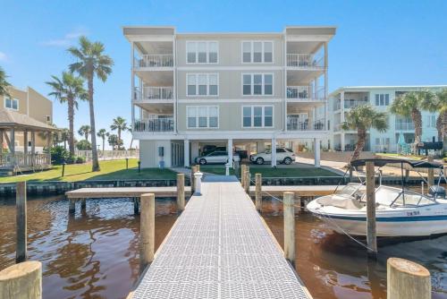 a large apartment building with a boat in a marina at Portside 204- Best of Beach & Bay in Orange Beach