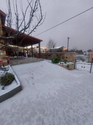 a patio with snow on the ground next to a building at Το Κονάτζι in Statos and Ayios Photios