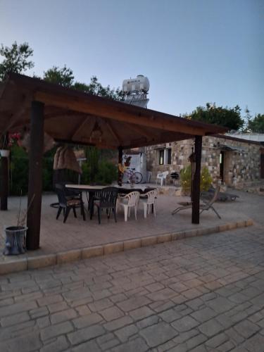 a pavilion with a table and chairs in a patio at Το Κονάτζι in Statos and Ayios Photios