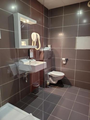 a bathroom with a toilet and a sink and a mirror at KYRIAD ORANGE Centre Ville - HOTEL & RESTAURANT & BAR - La Galerie d'Art des Princes - Provence Alpes Côte d'Azur - France - Proche A7-A9 - exit21- Châteauneuf-du-Pape Avignon Bollene Nimes - 24h-24h in Orange