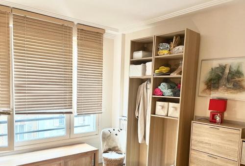 Cette chambre dispose d'une fenêtre avec des stores et une étagère. dans l'établissement calme et élégance, à Paris