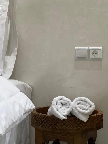 a bed with towels on a table next to a bed at Riad Safia in Rabat