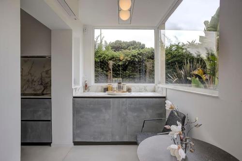 une cuisine avec un évier, une table et une fenêtre dans l'établissement Villa Julia First, à Vallauris