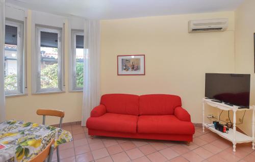 a red couch in a room with a bed and a tv at Villa Sandra in Marina di Modica
