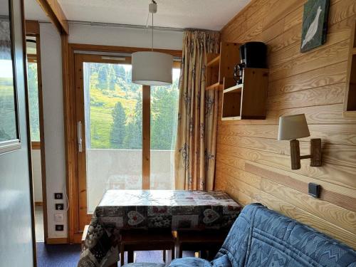 Cette petite chambre dispose d'une table et d'une fenêtre. dans l'établissement Studio fonctionnel accès pistes, balcon, animaux admis - FR-1-181-2273, à La Plagne Tarentaise
