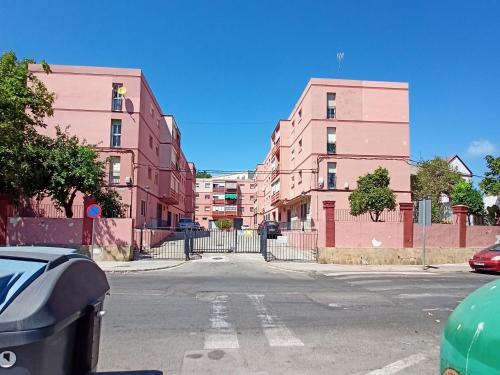 an empty street with pink buildings and a parking meter at Hospedaje casaAlfredo in Algeciras
