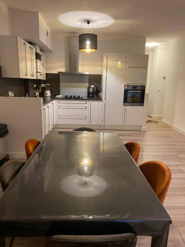 une cuisine avec une table et des chaises dans une cuisine dans l'établissement Spacieux en plein centre, à Sète