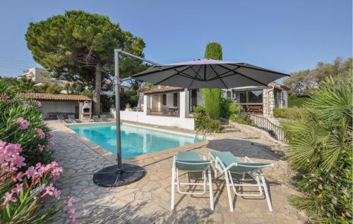 un patio avec deux chaises et un parasol à côté d'une piscine dans l'établissement Lovely Home In Antibes, à Antibes
