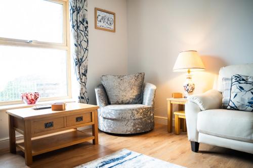 a living room with a rocking chair and a chair at Carreg Wen in Harlech