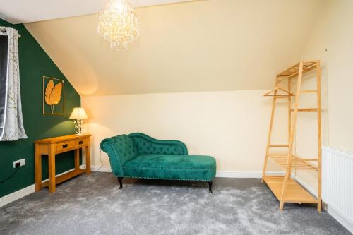 a living room with a green chair and a ladder at Carreg Wen in Harlech