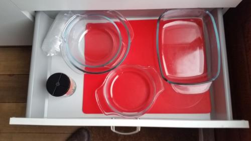 a drawer with four clear glasses and a red container at Bed & Breakfast 28 Appartement met Privé Tuin in Assen