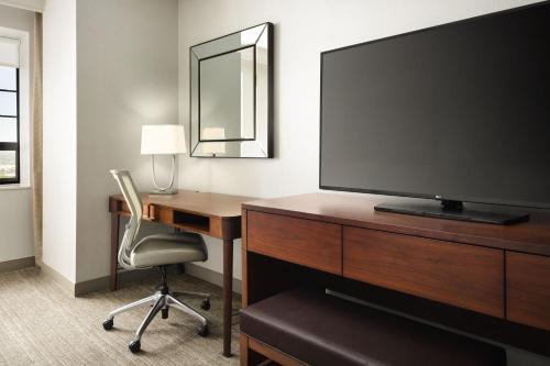 a hotel room with a desk and a flat screen tv at The Westin Portland Harborview in Portland