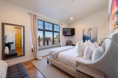パークシティにあるLespri by Park City Vacationsのベッドと大きな窓のある寝室
