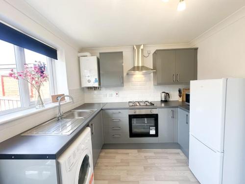 a kitchen with a white refrigerator and a dishwasher at No 203 by Blue Skies Stays in Stockton-on-Tees