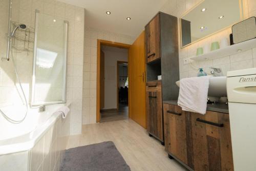 un bagno con vasca, lavandino e doccia di Ferienhof-Gerda-Ferienwohnung-Sternenhimmel a Oberkirnach