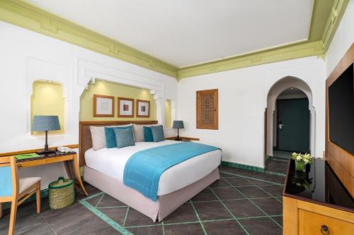 a bedroom with a large bed and a television at Jaal Riad Resort in Marrakech