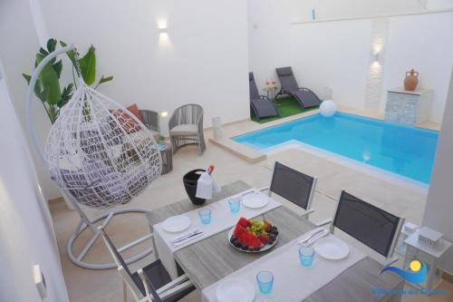 a living room with a table and a swimming pool at VILLA PERLA del SALENTO con piscina in Lido Marini