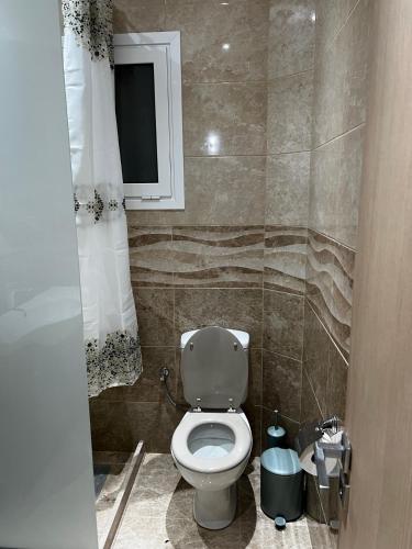 a small bathroom with a toilet and a window at Frosos house in Kefalos