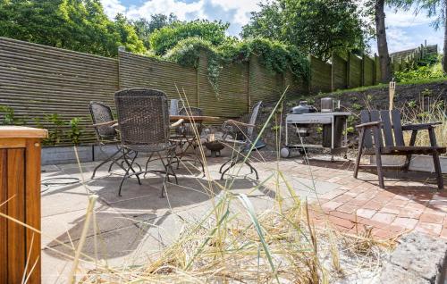 a patio with chairs and a table and a fence at 3 Bedroom Stunning Home In Nordborg in Nordborg