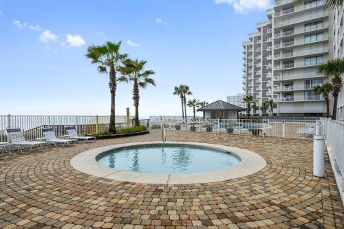a small pool with chairs and palm trees and a building at Windward Pointe 801- East corner-unit beachfront in Orange Beach