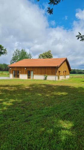 une grange avec un grand champ devant elle dans l'établissement Airial de Lachayre, à Lacquy