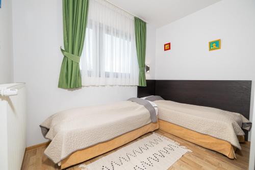 a bedroom with two beds and a window at Armonia by Aristocratis in Tîrgu Neamţ