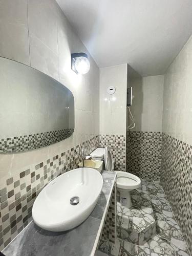 a white bathroom with a sink and a toilet at Lively Impact C3-C9 in Nonthaburi