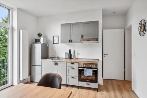a kitchen with a stove and a refrigerator at Sali Homes Apartmenthaus Bochum in Bochum