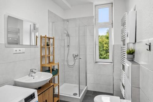 a white bathroom with a shower and a sink at Sali Homes Apartmenthaus Bochum in Bochum