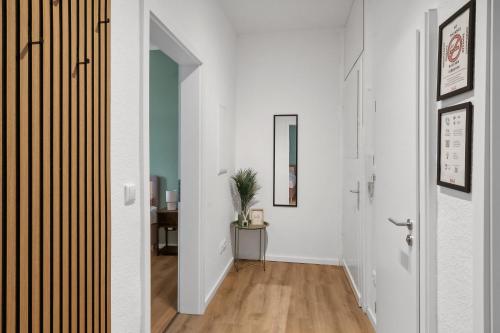 a hallway with white walls and wooden floors at Sali Homes Apartmenthaus Bochum in Bochum